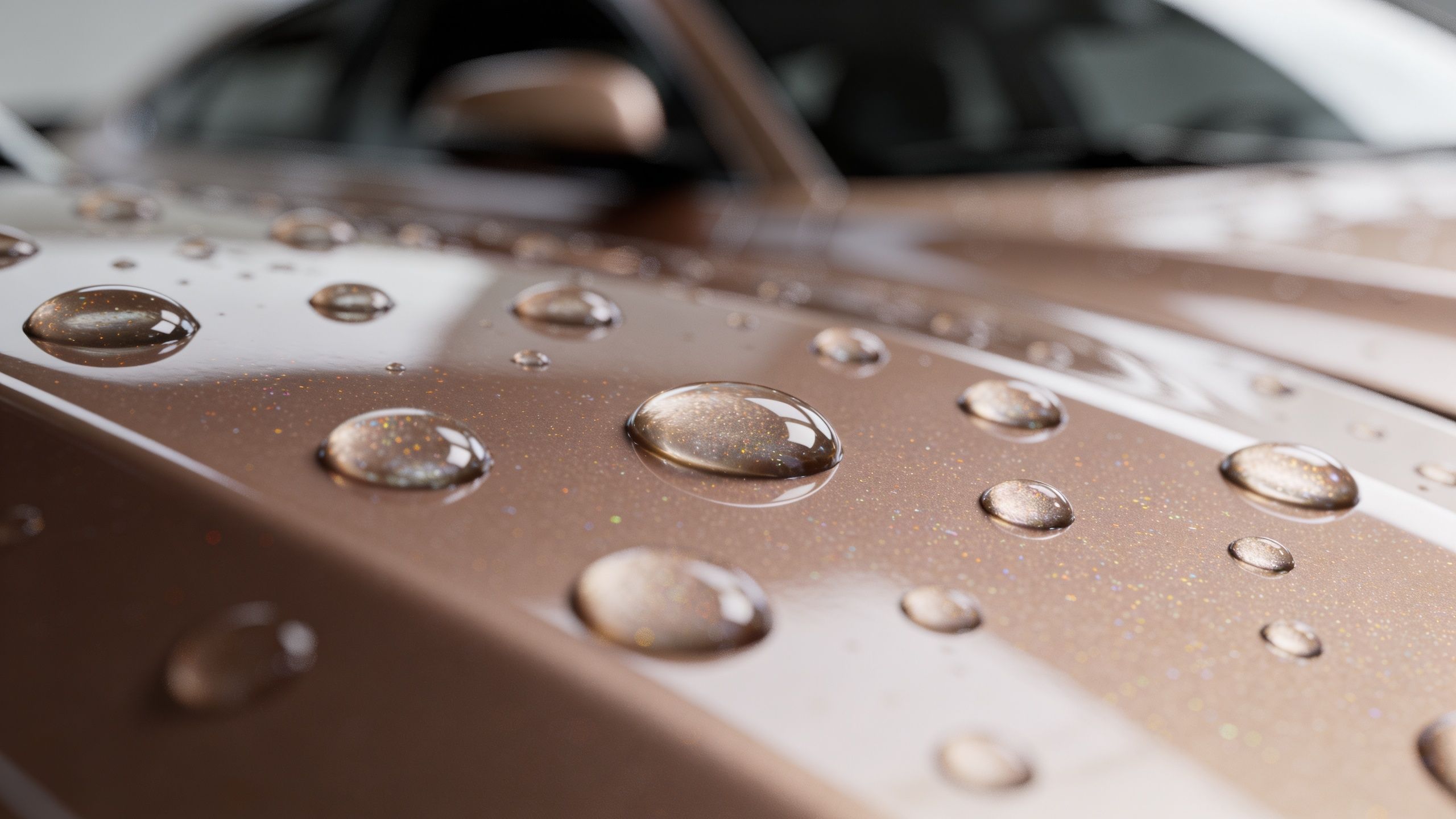 Close up of water beads sitting on the polished, metallic brown surface of a luxury car hood.